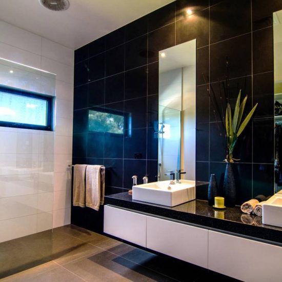 bathroom design, ensuite, black and white bathroom, countertop basin, black wall tiles, frameless shower, frameless shower screen, floating cabinet