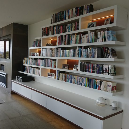 Custom joinery, bookcase, floating bookcase, floating cabinet, backlit shelves, timber lined shelves, tiled fireplace, recessed TV over fireplace